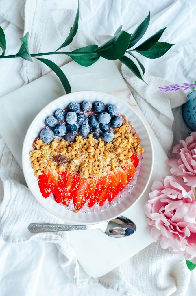 Berry smoothie breakfast bowl with berries , granola yoghurt and coconut