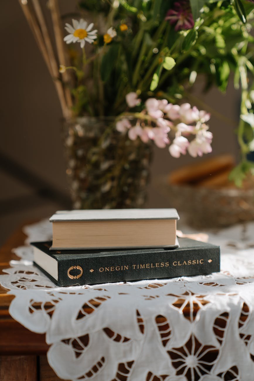 black and white book on white and brown floral table cloth