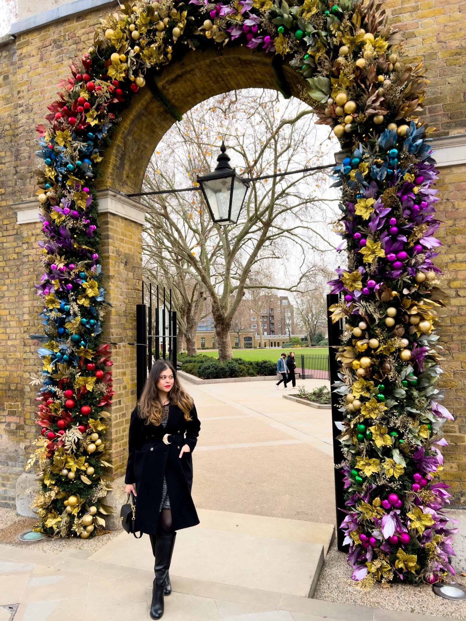 Duke of york square London, Girl dressed in Black long coat , Boucle dress and long boots in front of Saatchi Gallery in Chelsea. Most instagrammed places in London. 