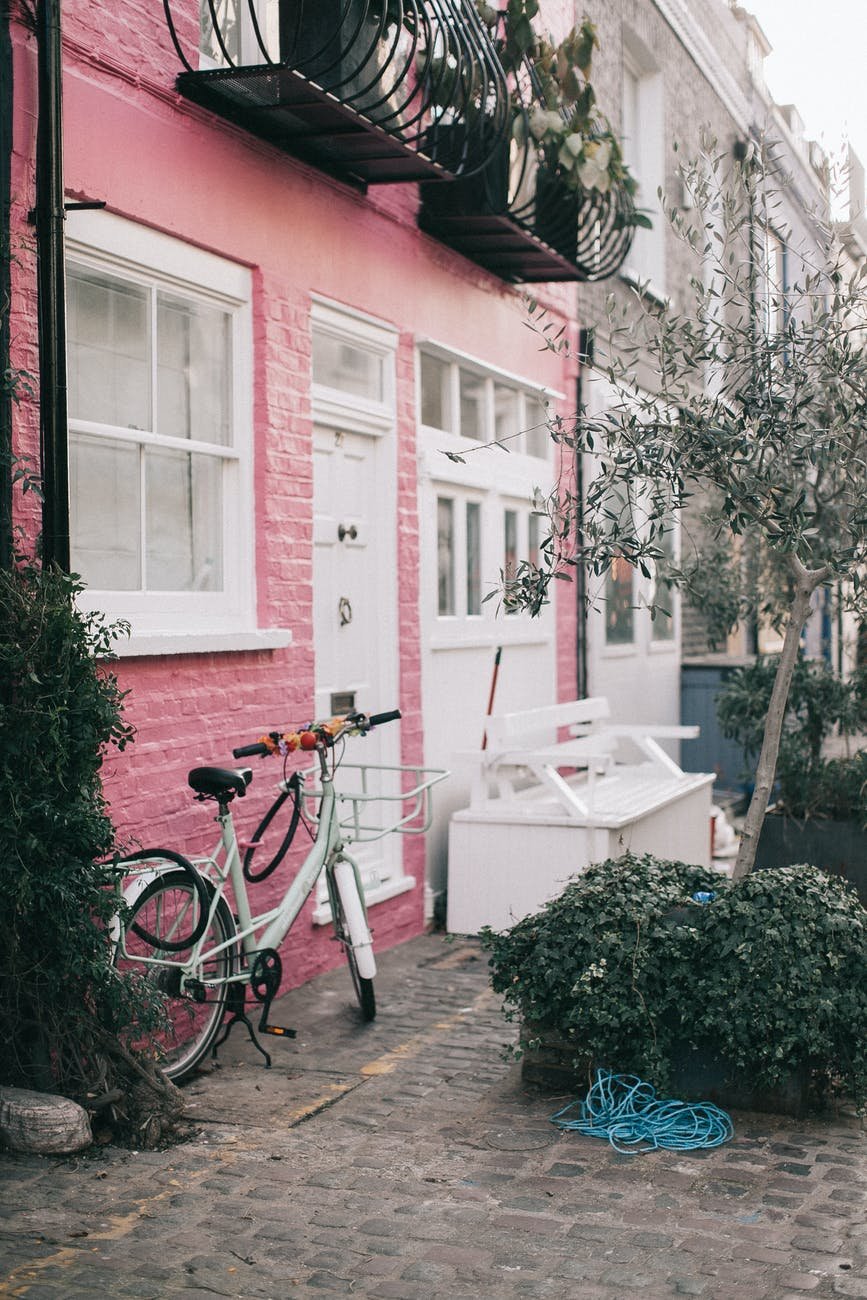white bicycle parked beside white and red concrete building. Notting Hill london