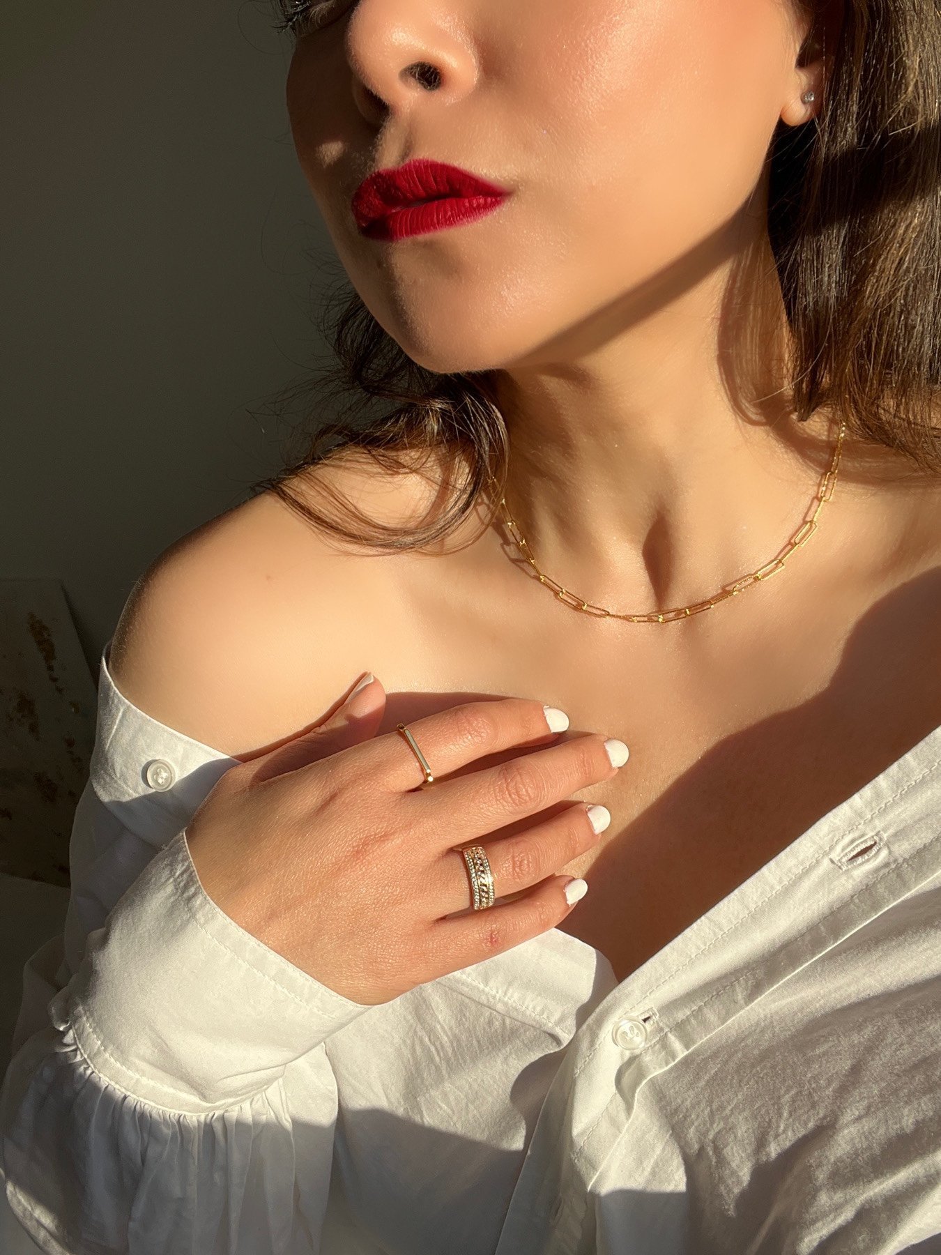 Monica Vinader jewellery on woman with red lips and white shirt