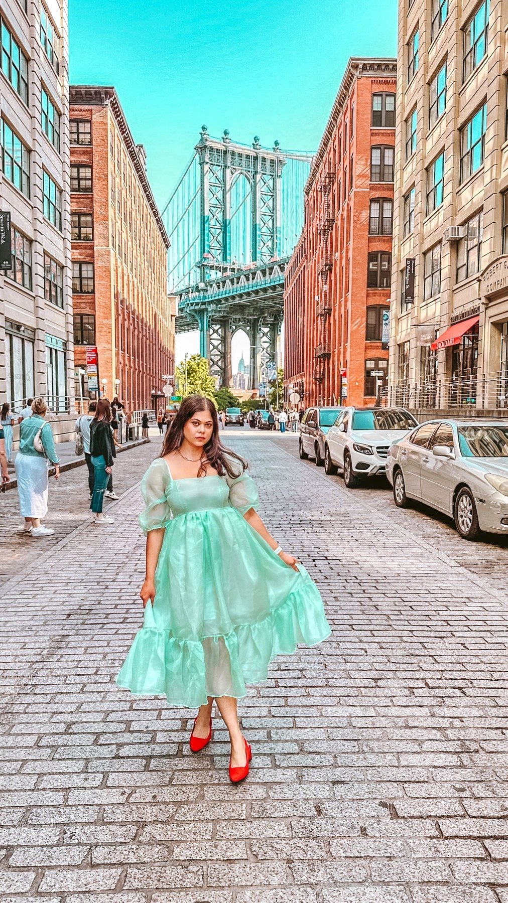 A picture of a girl in a beautiful organza dress standing in front of the Manhattan Bridge photo spot in the DUMBO area of Brooklyn. Things to do in New York| Colour me in style 