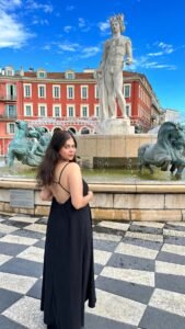 Pooja from Colour me ins tyle in front of a fountain in Nice France.