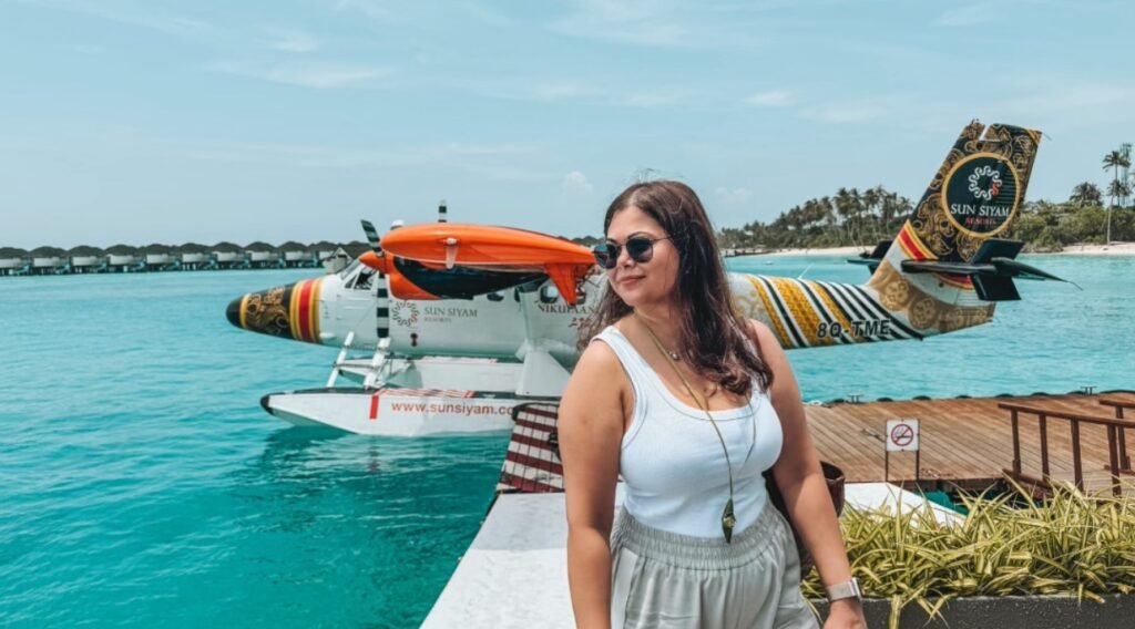 Pooja standing in front of a Maldives sea plane after arriving to Siyam World Maldives.