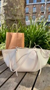 Charles and Keith Calla Tote Bag in Oat on a bench under a tree at Duke of York Square Chelsea London.