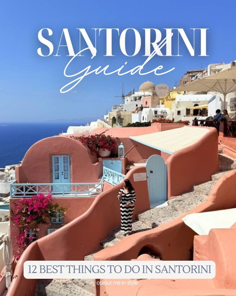 Pooja standing in front of the pink house of Oia Santorini