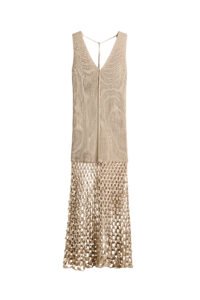 A long, sleeveless dress in a soft ribbed knit, designed with a fully fashioned bodice and a flattering V-neckline at both the front and back. Delicate ties fasten at the back of the neck, while an exposed front seam adds subtle detail. The skirt falls into a gently flared silhouette, finished with a crochet-look lower section for a textured, artisanal touch.