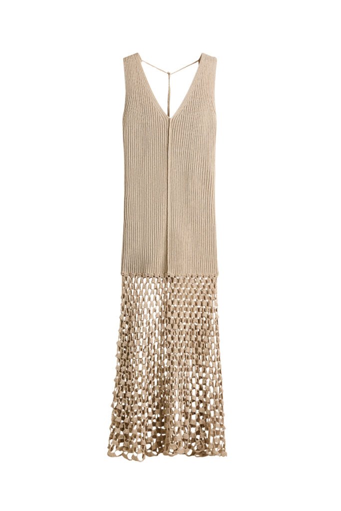 A long, sleeveless dress in a soft ribbed knit, designed with a fully fashioned bodice and a flattering V-neckline at both the front and back. Delicate ties fasten at the back of the neck, while an exposed front seam adds subtle detail. The skirt falls into a gently flared silhouette, finished with a crochet-look lower section for a textured, artisanal touch.