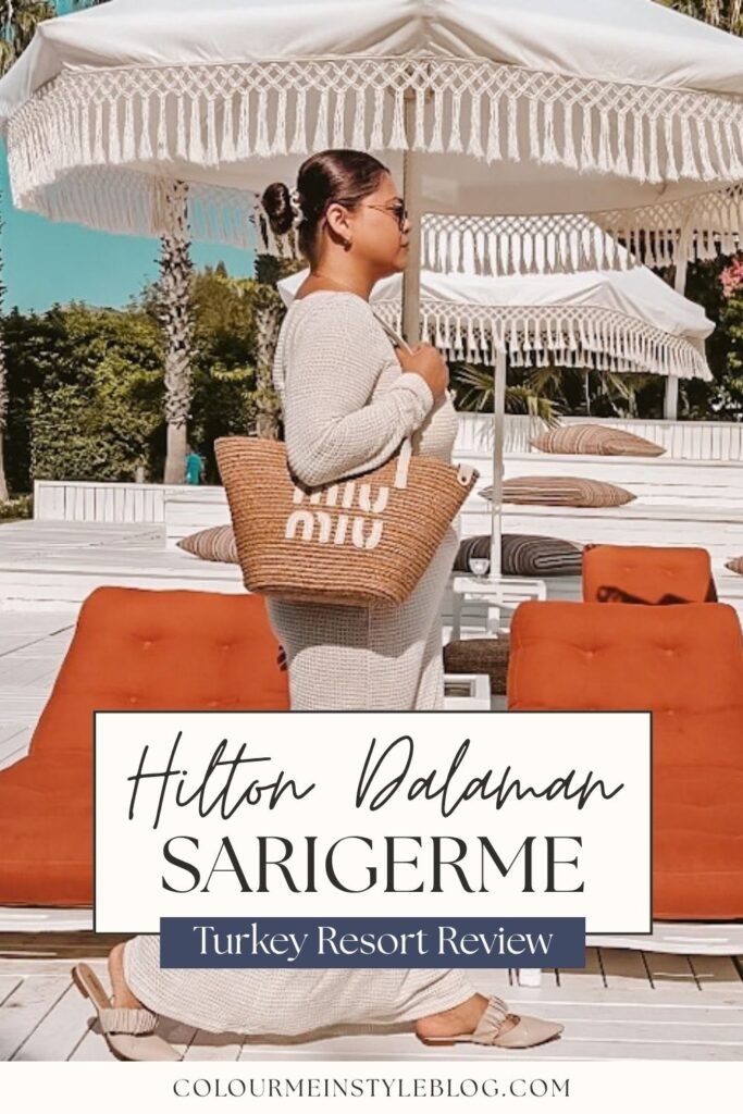 A woman in a white beach dress and a Miu Miu basket bag walking in front of a beach club in Hilton Dalaman Turkey