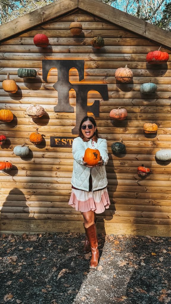A woman with a Tulleys farm branded pumpkin drink.